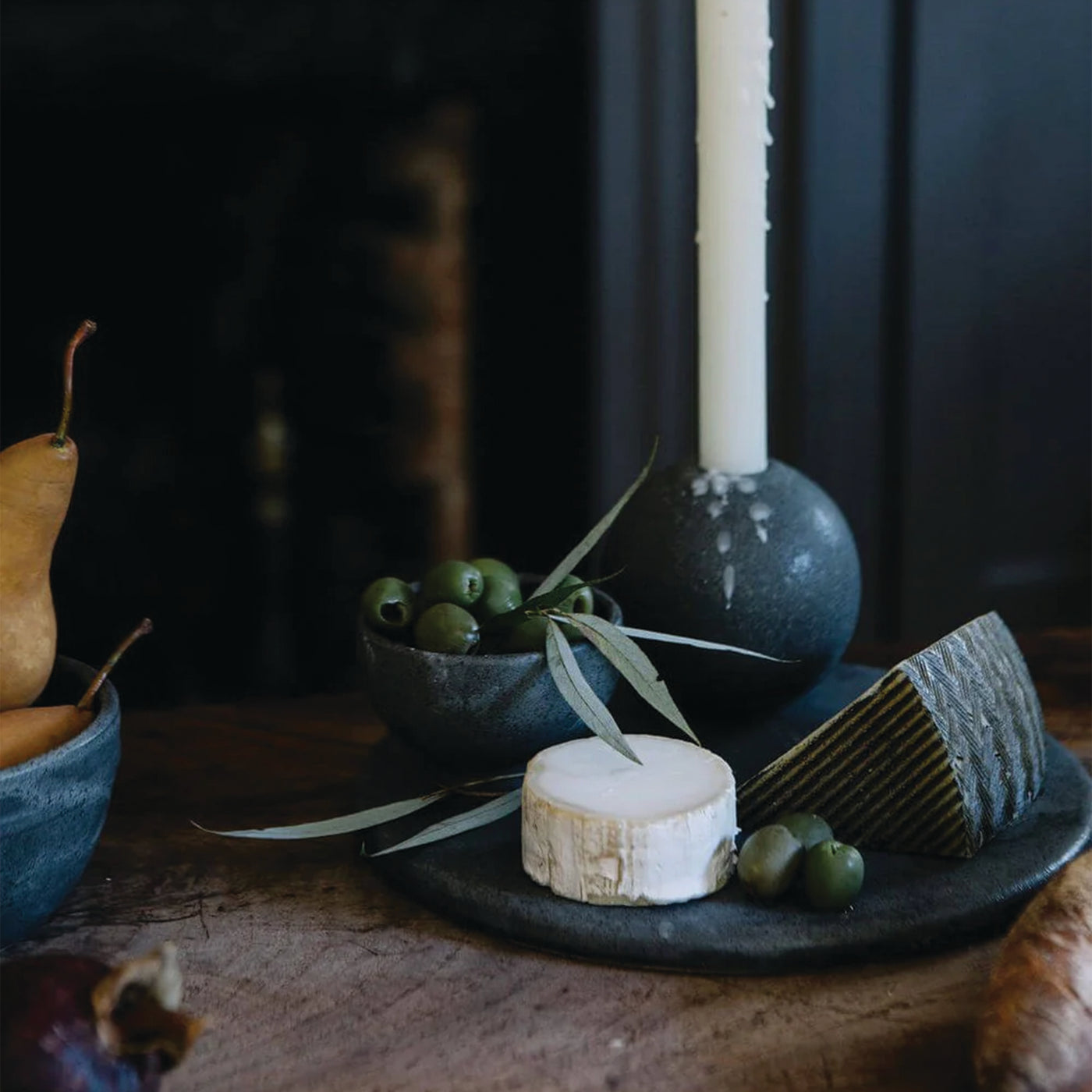 Charcoal Cheese Board with cheeses by Campfire Pottery on a wood table