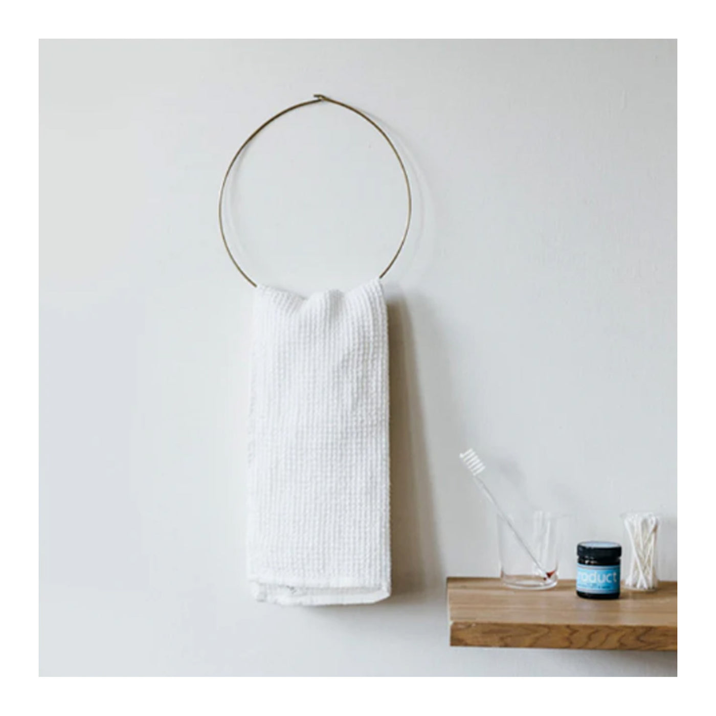 brass circle hook with white towel hanging