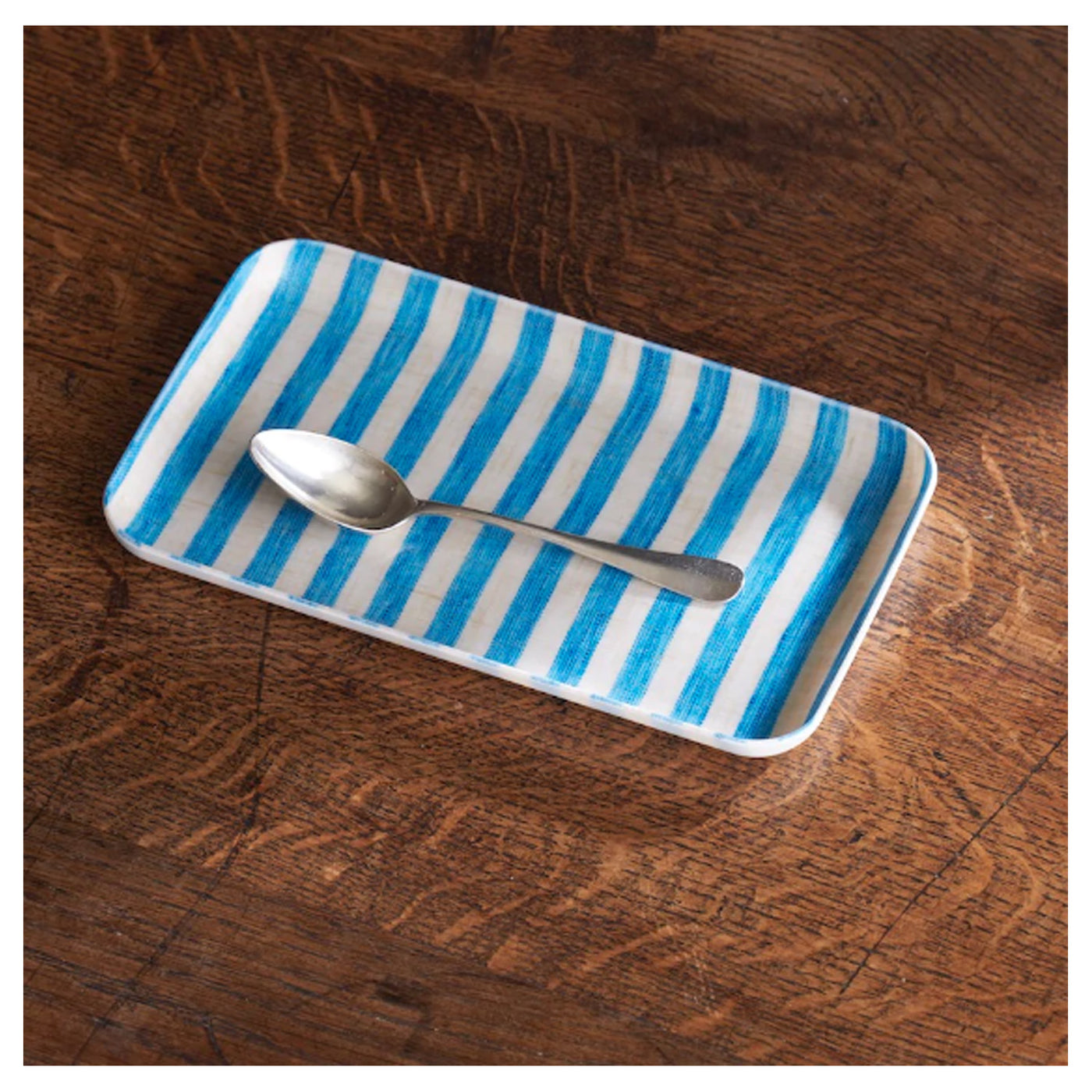 tray with blue and white stripes holding a spoon
