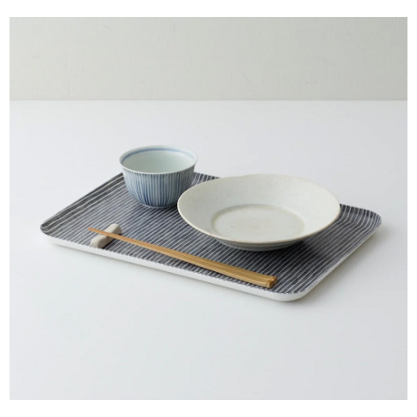 tray with gray and white stripes holding dishes